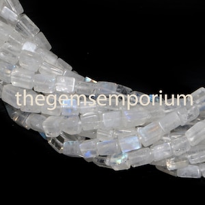 May include: A strand of white moonstone beads, each bead is rectangular and has a slight iridescent shimmer. The beads are arranged in a loose coil, with the ends of the strand visible. The background is black.