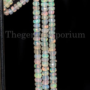 May include: A strand of white opal beads with a faceted, rectangular shape. The beads are strung on a wire and are approximately 6mm in size.