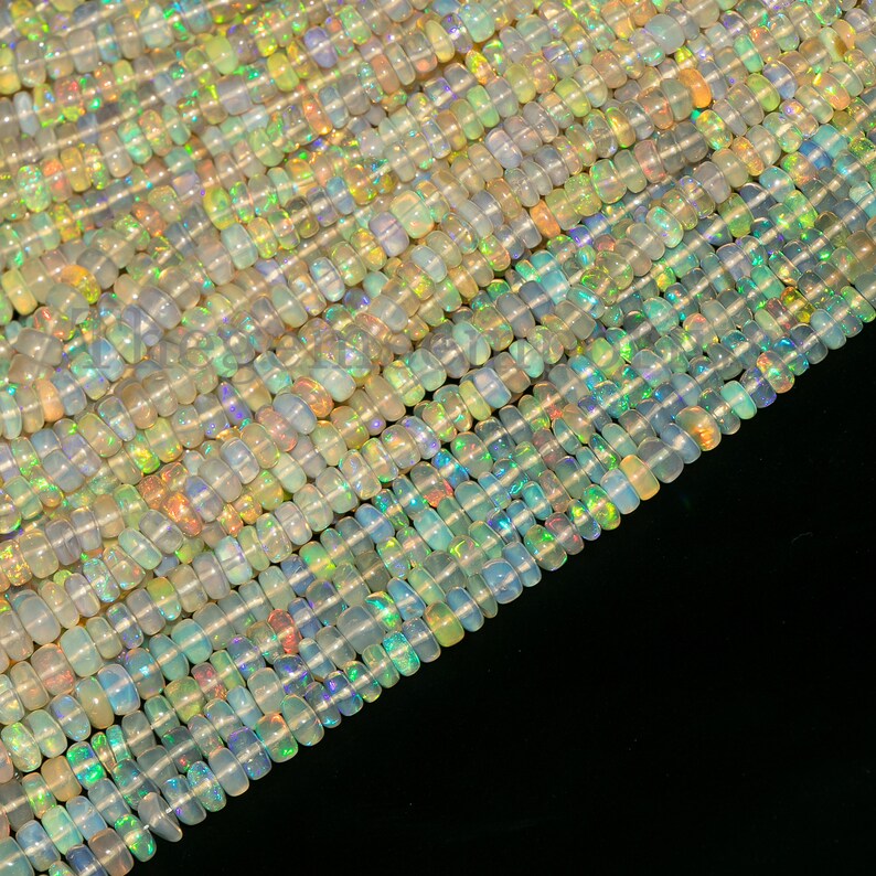 Puede incluir: Una hebra de cuentas de &oacute;palo iridiscente, con una variedad de colores y formas. Las cuentas est&aacute;n dispuestas en filas, creando un efecto brillante.