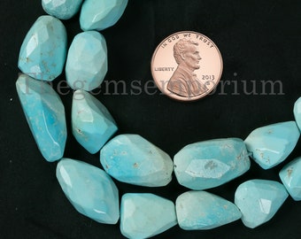 May include: A strand of turquoise gemstone beads, each bead is a unique, faceted, teardrop shape. The beads are a light blue colour and are arranged in a circle around a US penny for size reference. The penny is dated 2013.