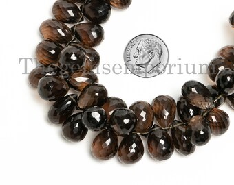 May include: A strand of brown faceted gemstone beads, resembling teardrops, with a US dime for scale.