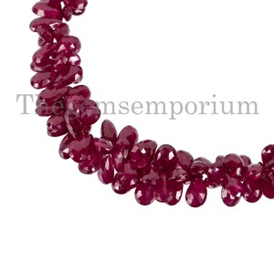 Puede incluir: Una hebra de cuentas de rubí rojo oscuro, cada cuenta está facetada y tiene forma de lágrima. Las cuentas están enhebradas para formar un collar o una pulsera.