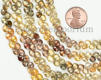 May include: A strand of faceted gemstone beads in shades of brown, yellow, and green. The beads are approximately the size of a UK penny, as shown in the image.