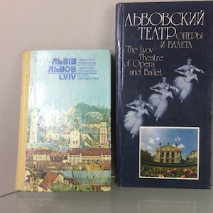 Puede incluir: Dos libros sobre Lviv, Ucrania. El libro de la izquierda es una guía turística con una foto de la ciudad en la portada. El libro de la derecha es sobre el Teatro de Ópera y Ballet de Lviv, con una foto de bailarines en la portada.