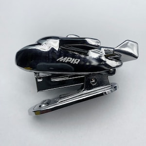 May include: A silver metal stapler shaped like a plane with the word "MPИЯ" printed on the side.