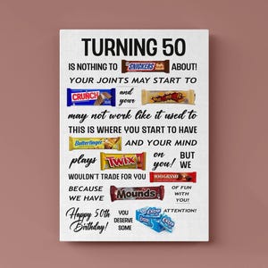 Op de afbeelding: Een wit rechthoekig bord met zwarte tekst: TURNING 50 IS NOTHING TO SNICKERS ABOUT, YOUR JOINTS MAY START TO CRUNCH AND YOUR WHATZAMACALLIT MAY NOT WORK LIKE IT USED TO, THIS IS WHERE YOU START TO HAVE BUTTERFINGER AND YOUR MIND PLAYS TWIX ON YOU BUT WE WOULDN'T TRADE FOR YOU BECAUSE WE HAVE 100 GRAND OF FUN WITH YOU, MOUNDS OF FUN, HAPPY 50TH BIRTHDAY, YOU DESERVE SOME EXTRA ATTENTION.