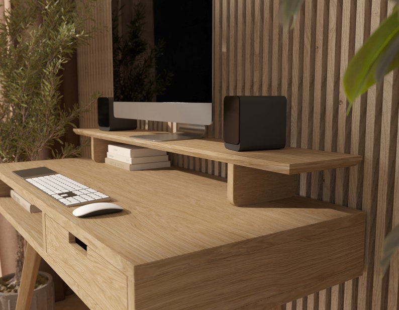 Puede incluir: Un escritorio de madera clara con un caj&oacute;n y un estante sobre el escritorio. El estante tiene dos altavoces negros y un monitor de ordenador. Hay un teclado y un rat&oacute;n en el escritorio.