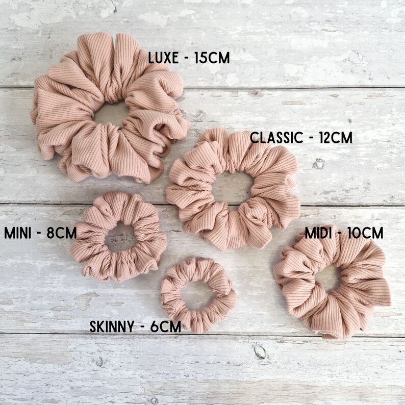 Pode incluir: Cinco tamanhos diferentes de scrunchies de cabelo canelados em uma cor marrom claro. Os scrunchies s&atilde;o rotulados com seu tamanho em cent&iacute;metros: LUXE - 15CM, CLASSIC - 12CM, MIDI - 10CM, MINI - 8CM e SKINNY - 6CM.