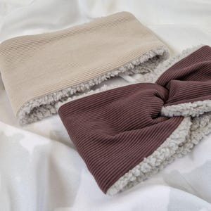 May include: A brown and beige headband with a fuzzy lining. The headband is made of a ribbed fabric.