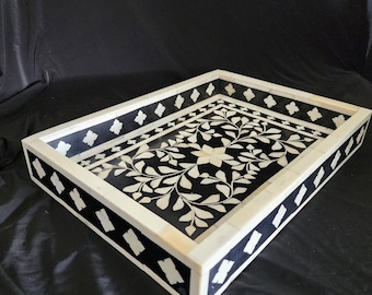 May include: A black and white rectangular tray with a floral design. The tray is made of bone inlay and has a decorative border.