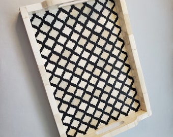 May include: A white tray with a black and white geometric pattern. The tray has a rectangular shape and is made of bone inlay.