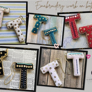 May include: Six felt letter ornaments in different colors, each with gold sequins and embroidery. The ornaments are in the shape of the letter "T" and are arranged in a collage. The text "Embroidery work on both sides" is visible at the top of the image.