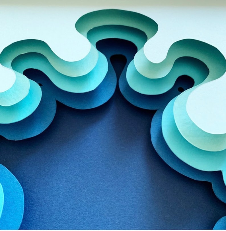 May include: Abstract paper art with layered, overlapping shapes in shades of blue and white. The shapes are cut out to create a 3D effect.
