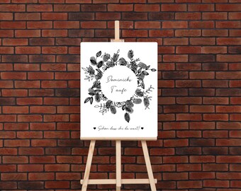 May include: A white sign with a black floral wreath and the text "Dominik's Taufe" in a circle. The text "Sieh'n dass du da bist!" is below the wreath.