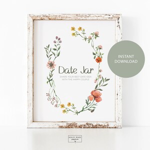 Peut inclure: Une affiche imprimable avec un motif de couronne florale et le texte "Date Jar" dans un cadre blanc. Le texte sous la couronne dit "Partagez votre meilleure idée de rendez-vous avec le couple heureux".