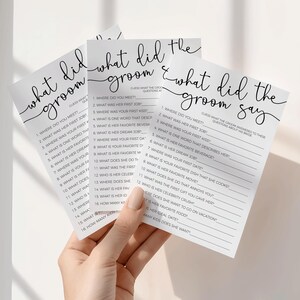Puede incluir: Tres tarjetas de juego rectangulares blancas con texto negro titulado What Did The Groom Say. Cada tarjeta presenta una lista de dieciséis preguntas numeradas para los invitados a la boda, incluyendo Where Did You Meet y How Many Kids Does She Want, impresas en una fuente sans-serif clara.