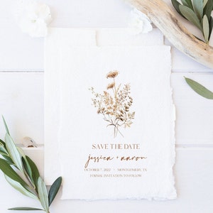 May include: Save the date card with a watercolor illustration of dried flowers in shades of brown and beige. The text reads "Save the Date Jessica + Aaron October 7, 2022 Montgomery, TX Formal Invitation to Follow."