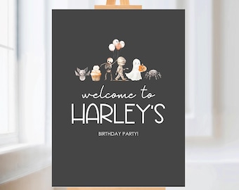 May include: A black welcome sign with a white border and white text that says "welcome to HARLEY'S BIRTHDAY PARTY!"  The sign features a line of cute Halloween characters including a ghost, a mummy, a skeleton, a bat, a cupcake, and a spider.
