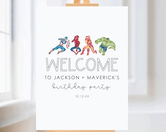 Op de afbeelding: Een wit welkomstbord op een houten ezel. Het bord toont aquarel illustraties van Captain America, Spider-Man, Iron Man en Hulk. De tekst luidt "WELCOME TO JACKSON + MAVERICK'S birthday party" met een datum eronder.
