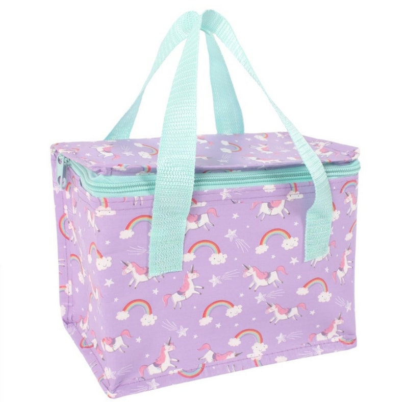May include: A rectangular lunch bag with a purple background featuring a pattern of unicorns, rainbows, and stars. It has a teal zip, teal handles, and a matching teal handle. The bag is designed to keep food and drinks cool.