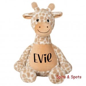 May include: A plush giraffe toy with a tan and white spotted pattern. The giraffe has a tan belly with the name "Evie" in black script. The toy has a smiling face and is designed for children.