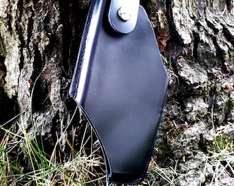May include: A black leather holster with a silver snap closure. The holster is designed to hold a small firearm.