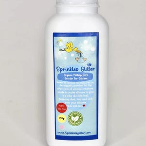 May include: A white plastic bottle of Sprinkles Glitter organic matting care powder for silicone. The label features a blue background with text and a yellow illustration. The bottle contains 130g of powder.