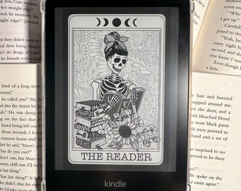 Può includere: Un'illustrazione in bianco e nero di uno scheletro che indossa una fascia per capelli e legge un libro. L'illustrazione è su uno sfondo bianco con il testo "THE READER" in lettere nere. L'immagine è visualizzata su un e-reader Kindle.