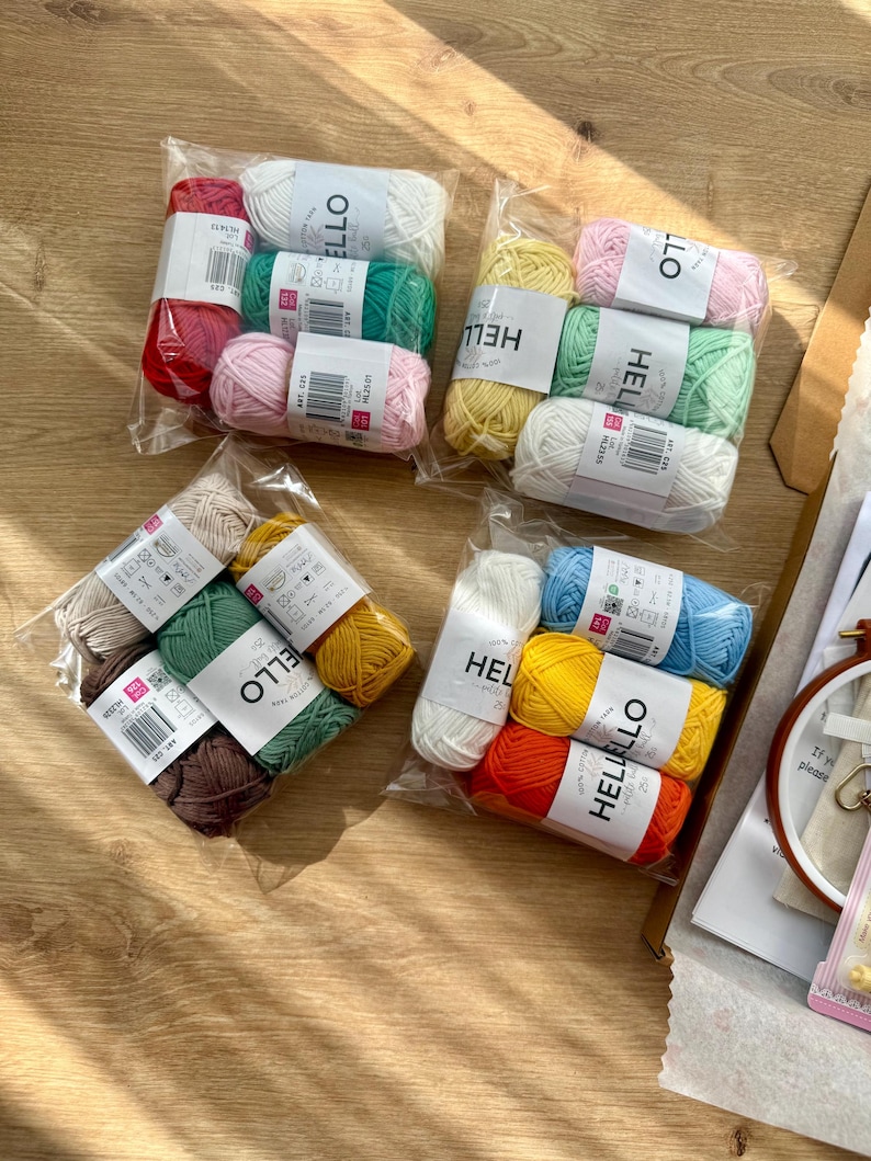 May include: Several packs of colourful yarn in clear plastic wrapping. The yarn shades include red, white, green, pink, yellow, brown, orange, and blue. Each pack is labelled with the word "HELLO".