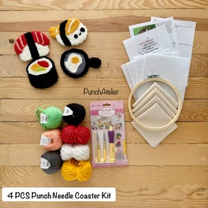 Op de afbeelding: Een 4-delige punch needle coaster kit met sushi- en eierontwerpen. De kit bevat garen in verschillende kleuren, punch needles, een borduurring en viltstof. De onderzetters zijn rood, wit, zwart, geel en groen. De tekst luidt: 4 PCS Punch Needle Coaster Kit.