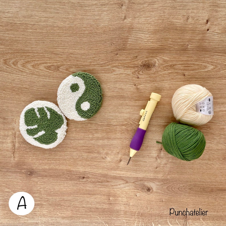 May include: Two punch needle projects, one with a yin yang design and the other with a monstera leaf design, are shown with two balls of yarn, one cream and one green, and a punch needle tool. The text "Punchatelier" is visible in the bottom right corner.