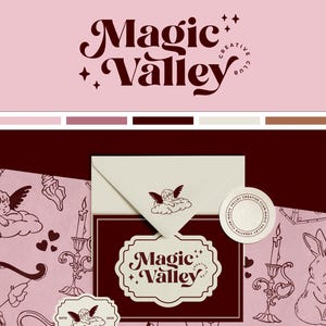 May include: A pink and white envelope with a brown seal featuring the text "Magic Valley Creative Club". The envelope is surrounded by a pattern of hearts, keys, cherubs, and candles on a pink background.