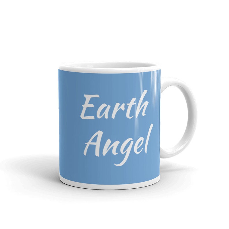 May include: A light blue ceramic mug with white text that reads "Earth Angel".