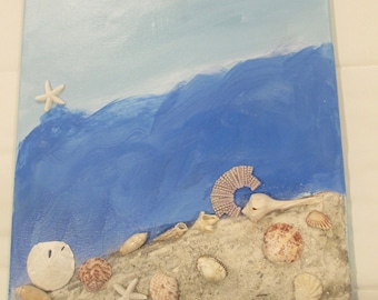 May include: A blue and white canvas painting with a seashell and starfish design. The painting features a blue wave with white foam and a sandy beach with seashells and a starfish.