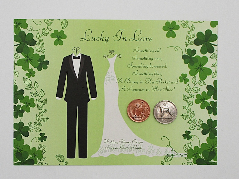 May include: A light green wedding card with the text "Lucky In Love" and a wedding rhyme. The card features illustrations of a tuxedo, a wedding dress, and two coins. Green shamrocks decorate the border.