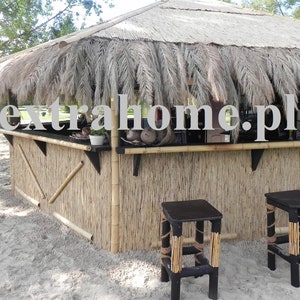 Puede incluir: Un bar con techo de paja, un frente de bamb&uacute; y dos taburetes negros. El bar est&aacute; decorado con hojas de palma y tiene un letrero que dice "extrahome.pl".
