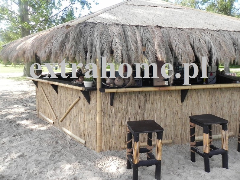 Puede incluir: Un bar con techo de paja, un frente de bamb&uacute; y dos taburetes negros. El bar est&aacute; decorado con hojas de palma y tiene un letrero que dice "extrahome.pl".