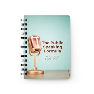 Puede incluir: Una libreta azul con un micrófono dorado en la portada. La libreta dice "The Public Speaking Formula Notebook" en la parte delantera.