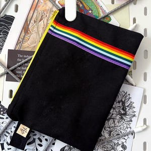 PROUD P • Reißverschlusstasche aus Baumwolle mit einem aufgenähten Regenbogenband auf der Außenseite.