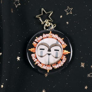 The Front of the Esquie Keychain. It features Esquie's head from Clair Obscur Expedition 33 featuring the text: "I am too "Whooo" but I am also "Wheee"