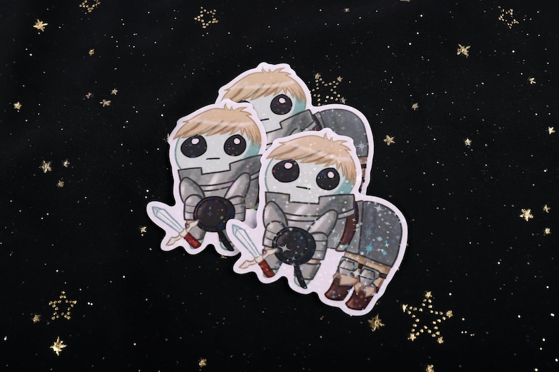 A holographic sticker Of Laios Touden  of Dungeon Meshi / Delicious in dungeon imagined as the yippee / Autism Creature. The sticker is on a black background with gold glitter.
