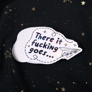 A sticker with the phrase "There it fucking goes..." and a small paper airplane graphic flying away that says "My Last Fuck"