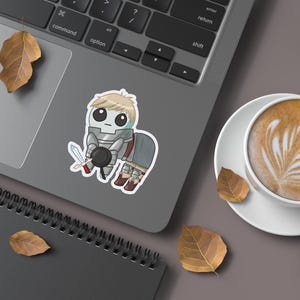 A mockup of a holographic sticker Of Laios Touden  of Dungeon Meshi / Delicious in dungeon imagined as the yippee / Autism Creature on the laptop.
