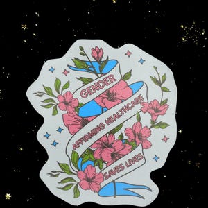 May include: A sticker with a white background, featuring a blue ribbon with the words "GENDER AFFIRMING HEALTHCARE SAVES LIVES." Pink flowers and green leaves surround the ribbon. Blue star shapes are scattered around the sticker.