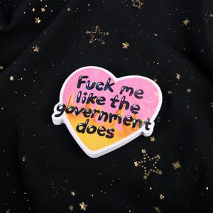 A flaming heart-shaped sticker with the text "Fuck me like the government does"