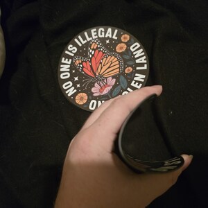 The magnet is bent, showing it's thickness and flexibility.