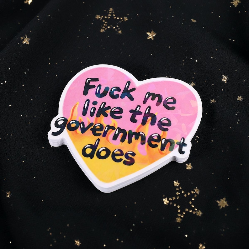 A flaming heart-shaped sticker with the text "Fuck me like the government does"