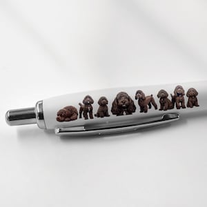 May include: A white pen with a black grip and a design of brown dogs on the barrel.