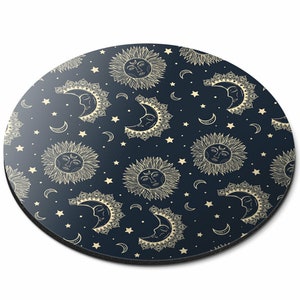 May include: A round, dark blue mouse mat with a repeating pattern of gold suns and moons with faces, and small gold stars.