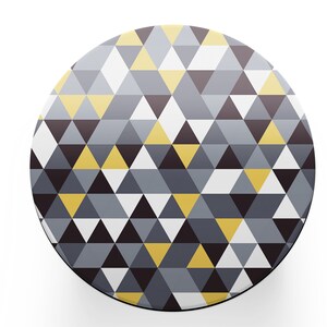 May include: A round phone grip with a geometric pattern of yellow, grey, and black triangles.